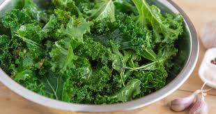 Chopped kale being prepared with garlic